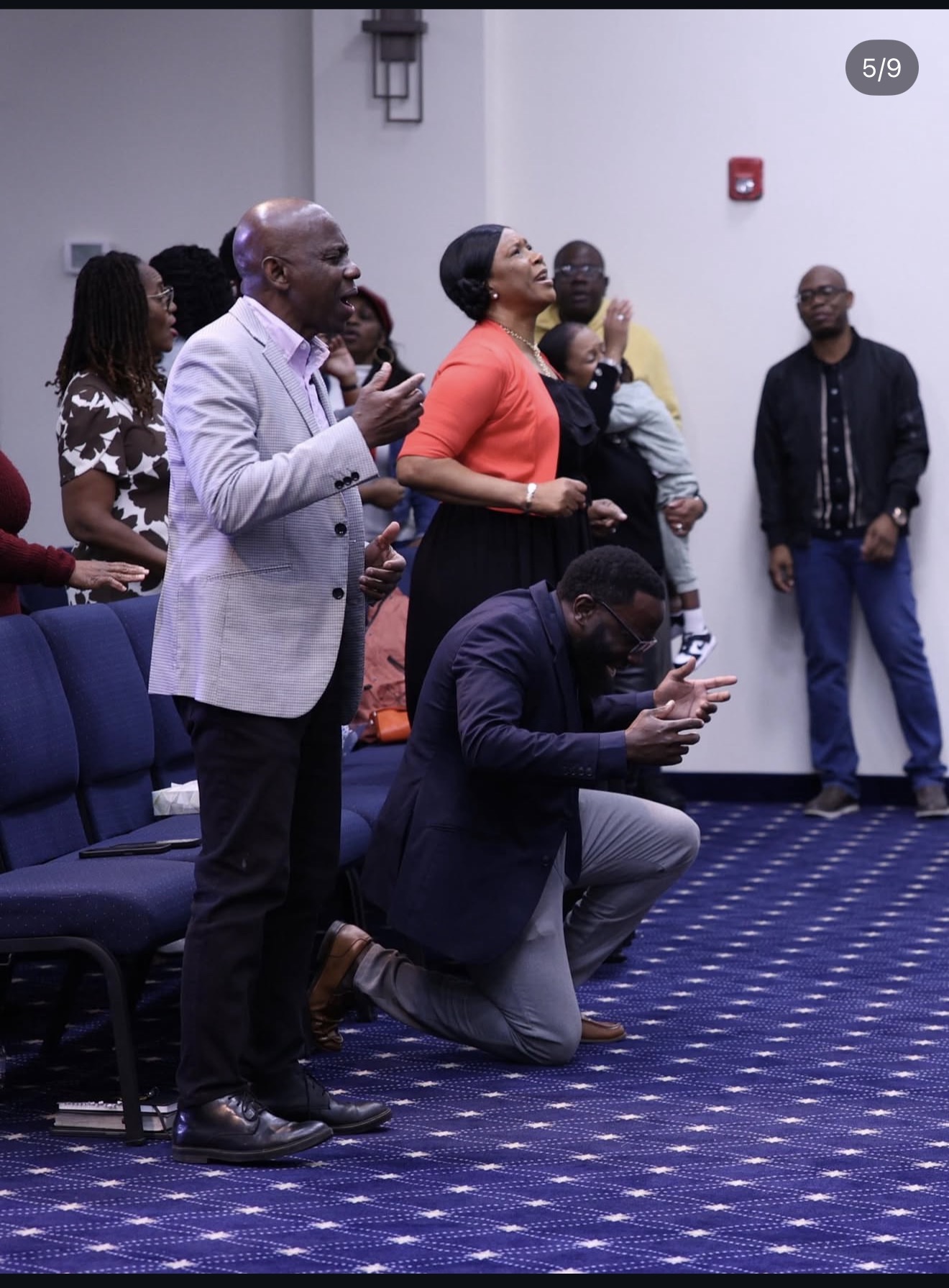 Rehoboth Open Bible Church leaders and congregation praying during worship